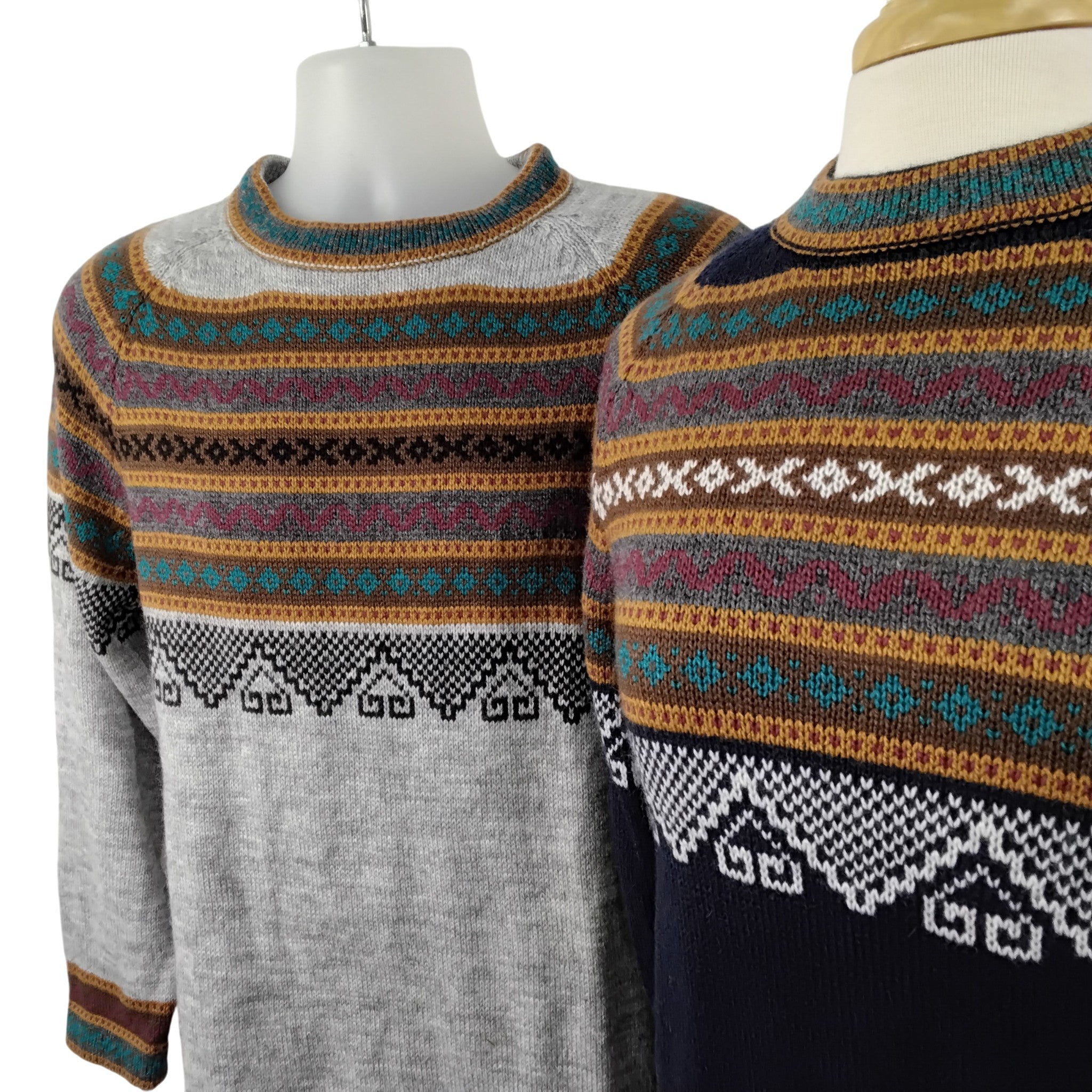 Two patterned sweaters on mannequins with a white background