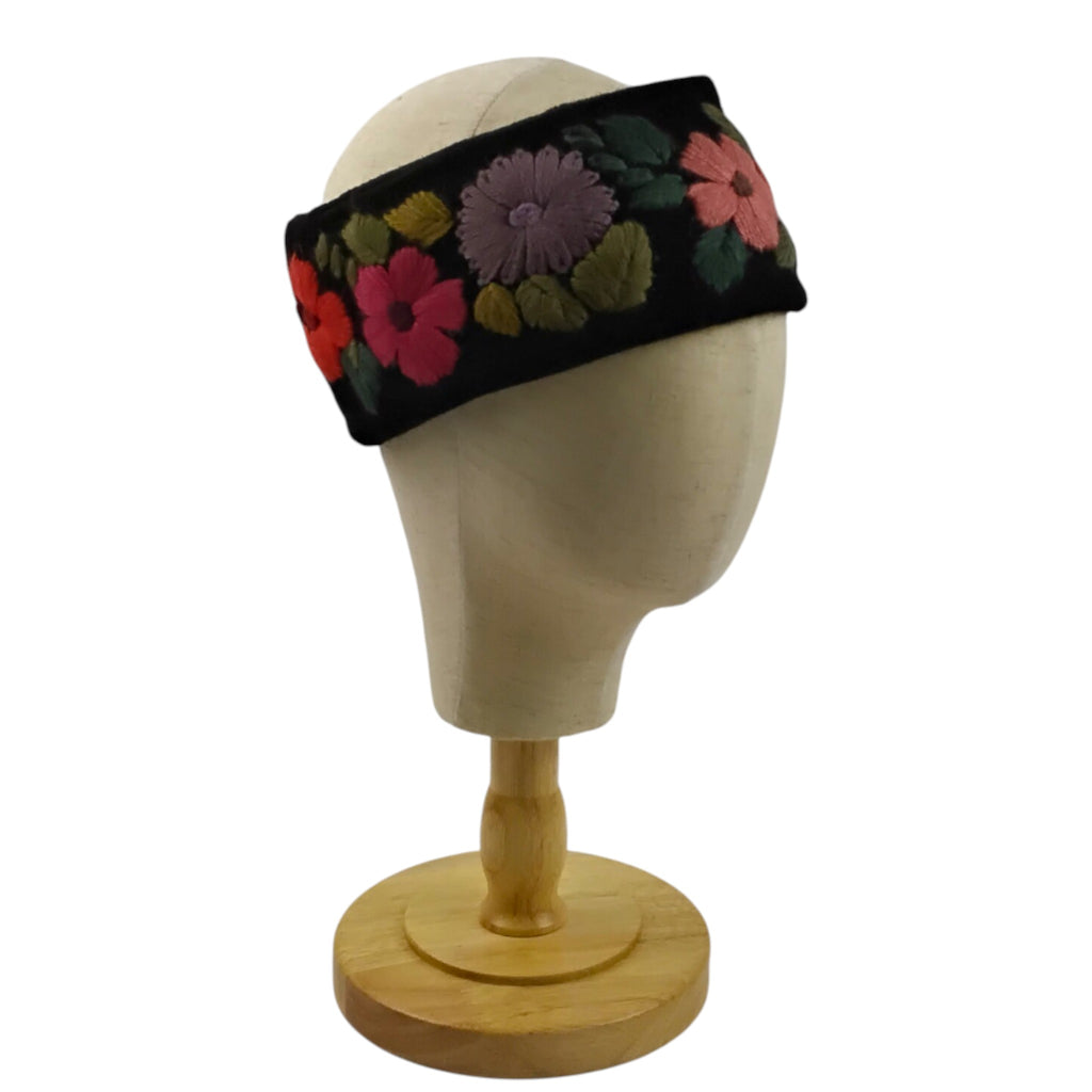 black floral headband on a mannequin head with a white background