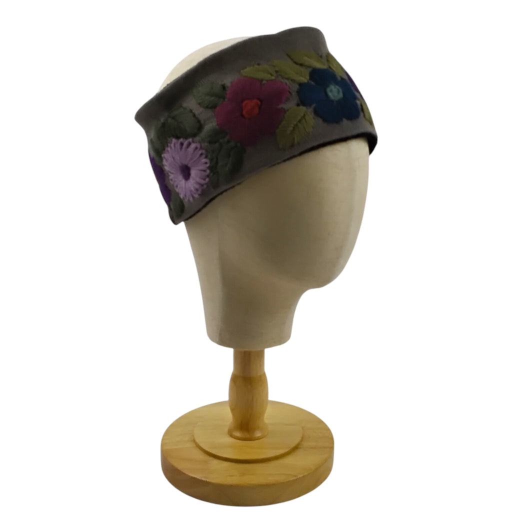 Gray skiband with floral patterns on a mannequin head against a white background