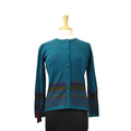 Blue cardigan with a patterned hem on a mannequin against a white background